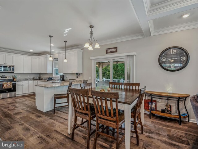 dining area with an inviting chandelier, crown molding, dark hardwood / wood-style floors, and sink