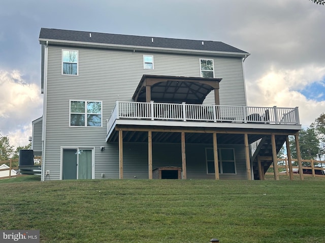 back of property with a wooden deck and a yard