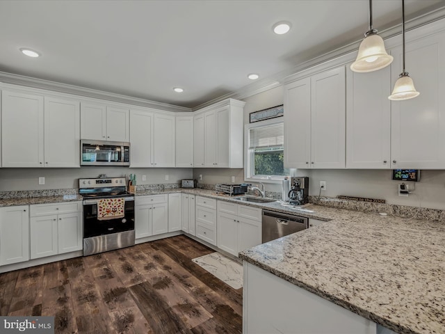 kitchen featuring pendant lighting, light stone counters, white cabinets, appliances with stainless steel finishes, and dark hardwood / wood-style flooring