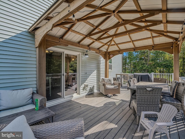 wooden terrace featuring an outdoor hangout area and a gazebo