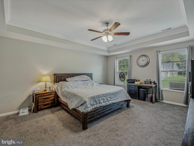 carpeted bedroom with multiple windows, a raised ceiling, ceiling fan, and crown molding