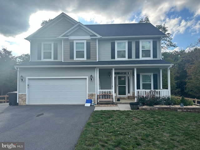 view of front of home featuring a front yard, a porch, and a garage