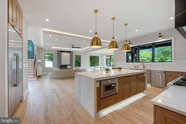 kitchen with light stone countertops, a wealth of natural light, a large island, and stainless steel appliances