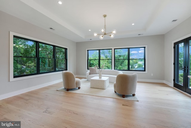 unfurnished room featuring a notable chandelier and light wood-type flooring