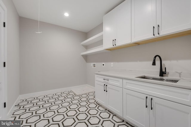 clothes washing area with washer hookup, cabinets, sink, and hookup for an electric dryer