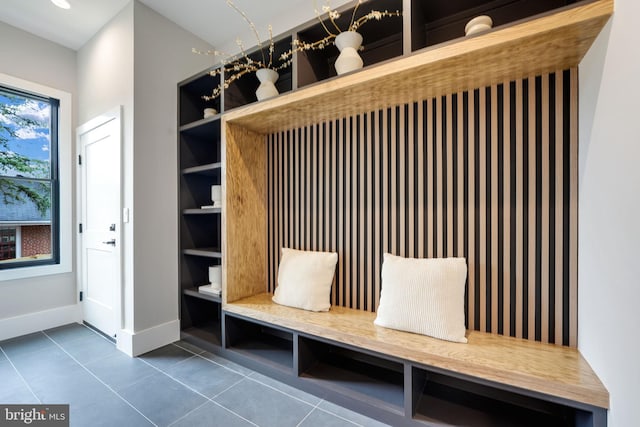 mudroom with dark tile patterned floors