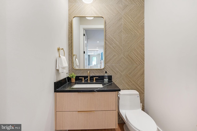 bathroom with tile walls, vanity, and toilet