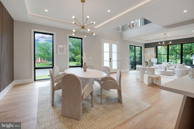 dining room with light wood-type flooring, a chandelier, and plenty of natural light