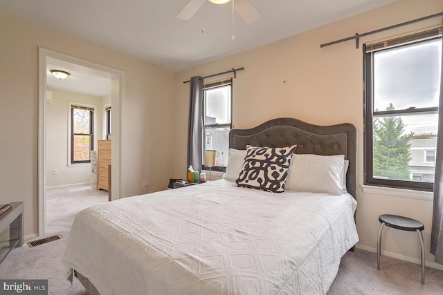 carpeted bedroom featuring multiple windows, ceiling fan, and a barn door