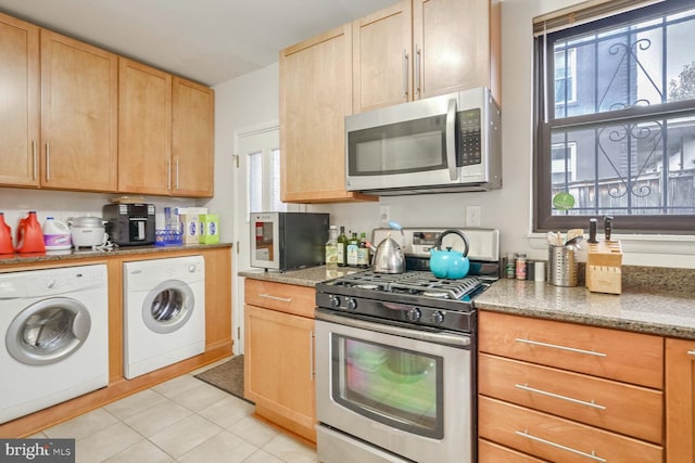 kitchen featuring a healthy amount of sunlight, light tile patterned floors, separate washer and dryer, and appliances with stainless steel finishes