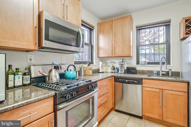 kitchen featuring stone counters, sink, plenty of natural light, and appliances with stainless steel finishes