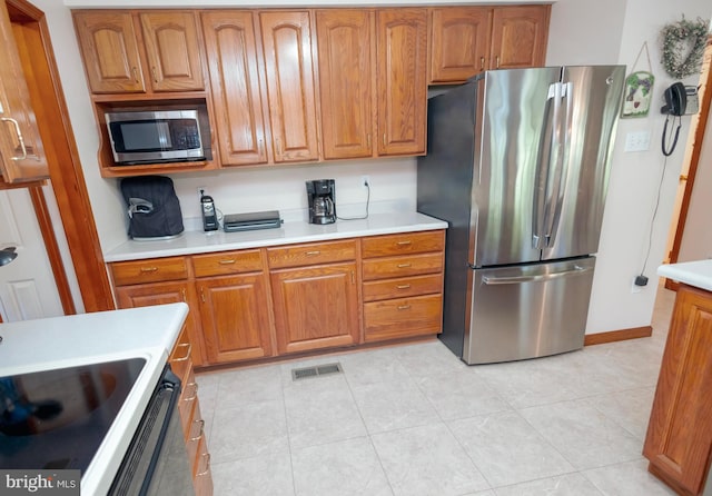 kitchen featuring light tile patterned flooring and stainless steel appliances