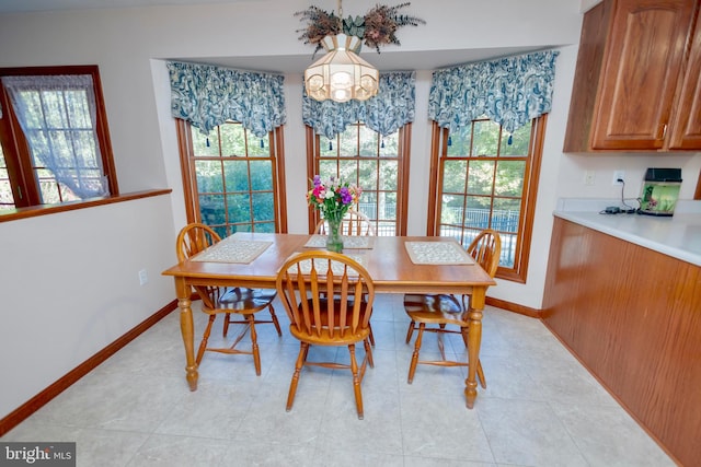 dining room featuring a notable chandelier, plenty of natural light, and light tile patterned floors