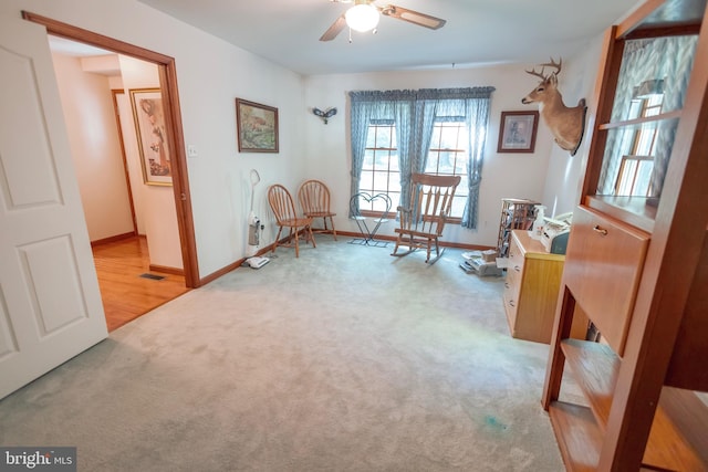 sitting room with ceiling fan and light carpet