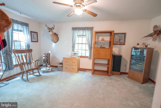 sitting room featuring ceiling fan, light colored carpet, and a healthy amount of sunlight