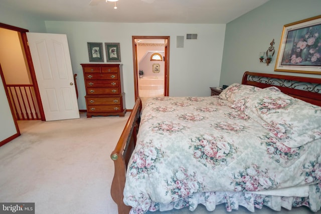 carpeted bedroom featuring ceiling fan and ensuite bath