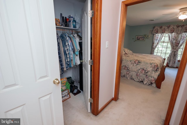 bedroom featuring a closet, light colored carpet, and ceiling fan