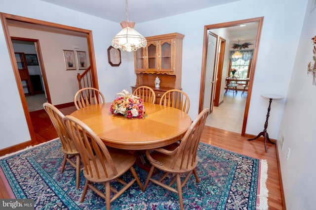 dining area with a notable chandelier and light hardwood / wood-style floors