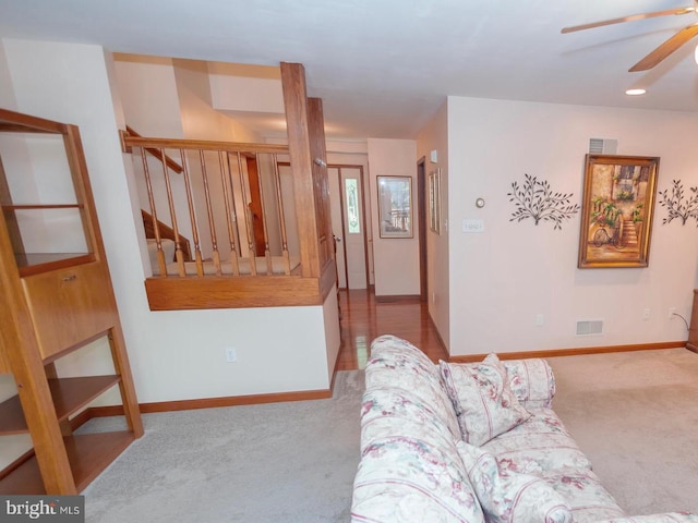 carpeted living room with ceiling fan