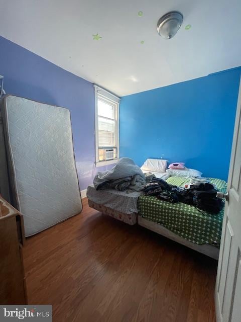 bedroom featuring cooling unit and dark hardwood / wood-style flooring