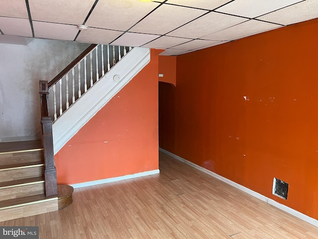 basement with a drop ceiling and hardwood / wood-style floors