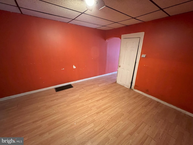 spare room with light wood-type flooring and a drop ceiling