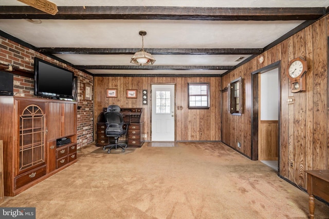 unfurnished living room featuring carpet, wood walls, and beamed ceiling