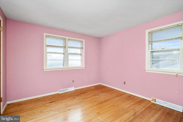 unfurnished room with hardwood / wood-style flooring