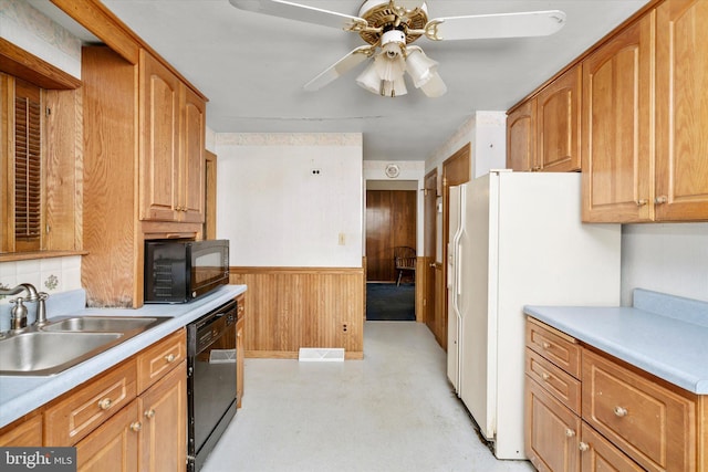 kitchen with ceiling fan, black appliances, sink, and wooden walls