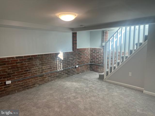 basement with brick wall and carpet