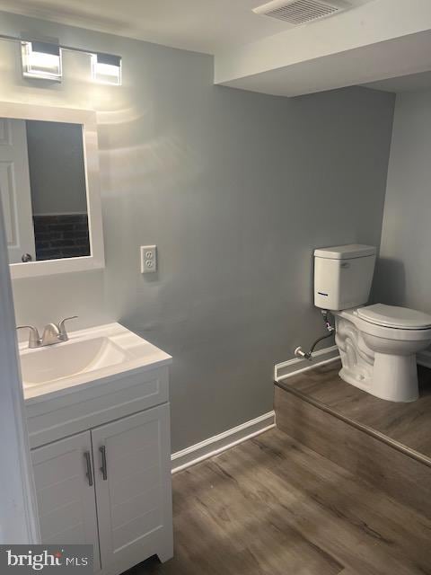 bathroom featuring vanity, toilet, and wood-type flooring