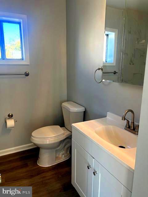 bathroom featuring vanity, toilet, and hardwood / wood-style flooring