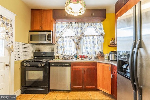 kitchen featuring light tile patterned floors, appliances with stainless steel finishes, sink, and backsplash