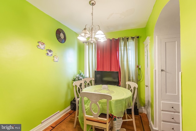 dining room with hardwood / wood-style flooring and a notable chandelier