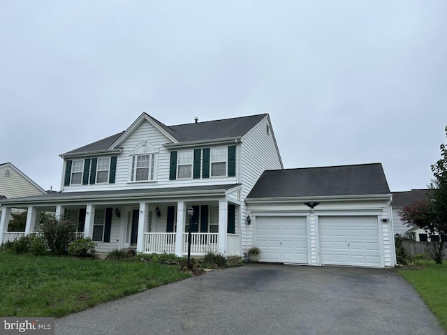 view of front facade featuring covered porch, a front yard, and a garage