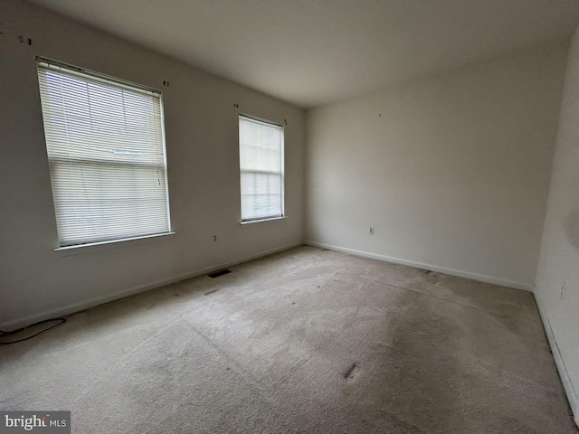 unfurnished room featuring light carpet