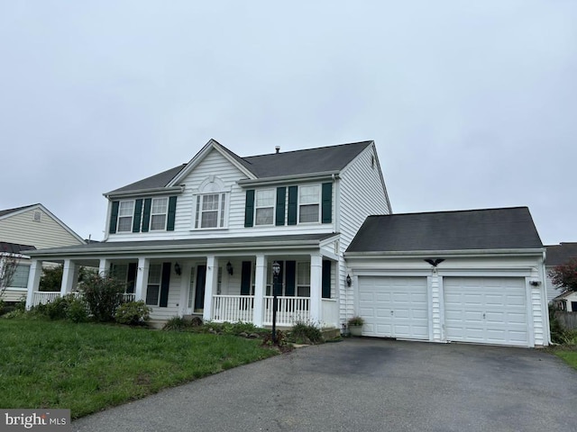 view of front of home featuring a front yard, a porch, and a garage