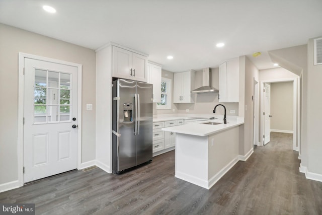 kitchen featuring white cabinets, sink, wall chimney range hood, stainless steel refrigerator with ice dispenser, and dark hardwood / wood-style floors