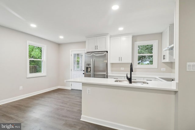 kitchen featuring white cabinets, stainless steel refrigerator with ice dispenser, plenty of natural light, and sink