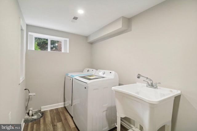 laundry room featuring washer and clothes dryer, dark hardwood / wood-style flooring, and sink