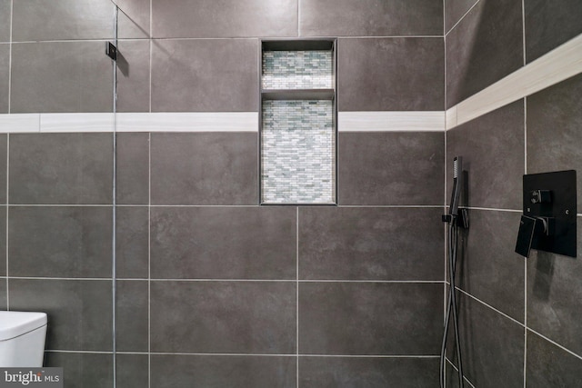 details featuring tiled shower and toilet