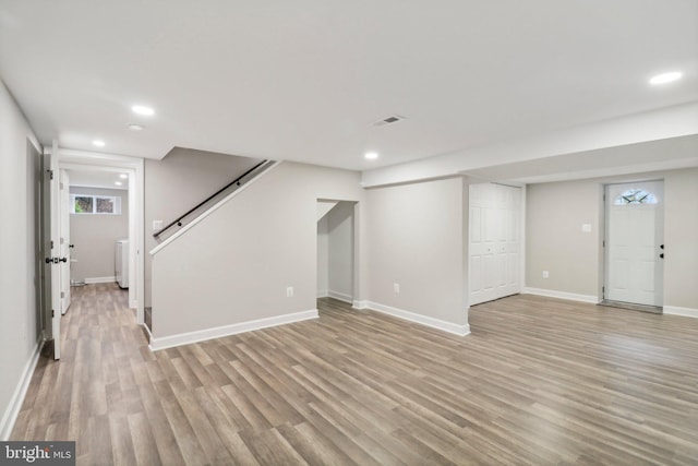 basement with light hardwood / wood-style flooring