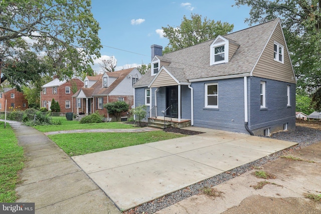 cape cod home featuring a front lawn