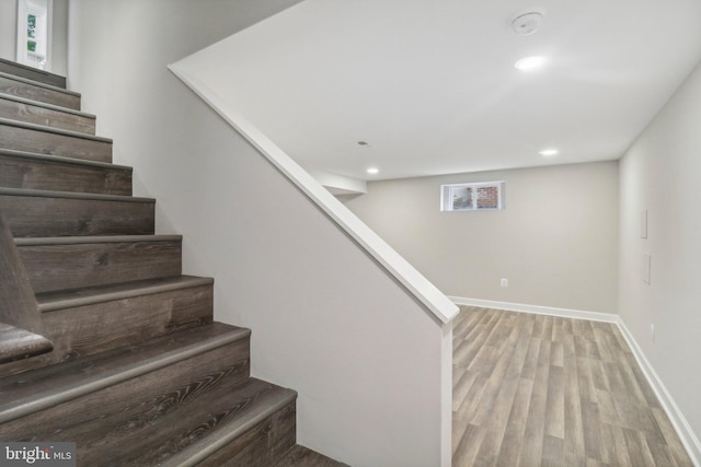 stairs featuring hardwood / wood-style floors