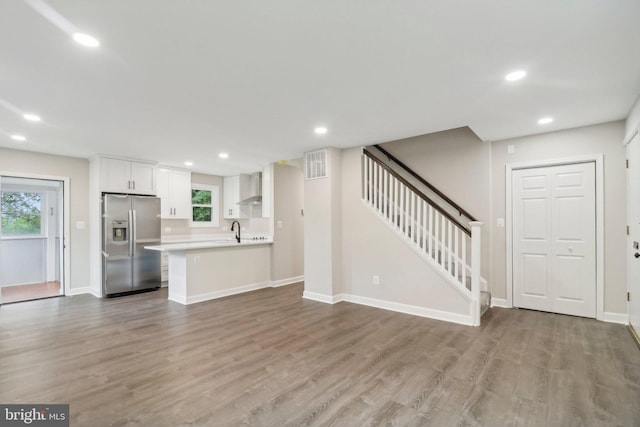 unfurnished living room with light hardwood / wood-style floors and sink