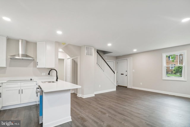 kitchen featuring sink, wall chimney range hood, white cabinetry, dark hardwood / wood-style floors, and cooktop