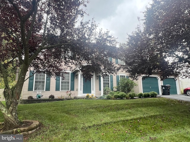 obstructed view of property featuring a garage and a front yard