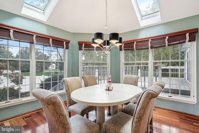 sunroom featuring lofted ceiling, a notable chandelier, and plenty of natural light