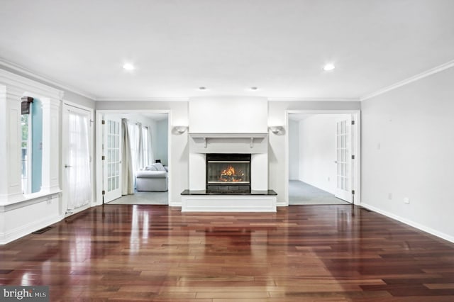 unfurnished living room featuring french doors, decorative columns, crown molding, and dark wood-type flooring