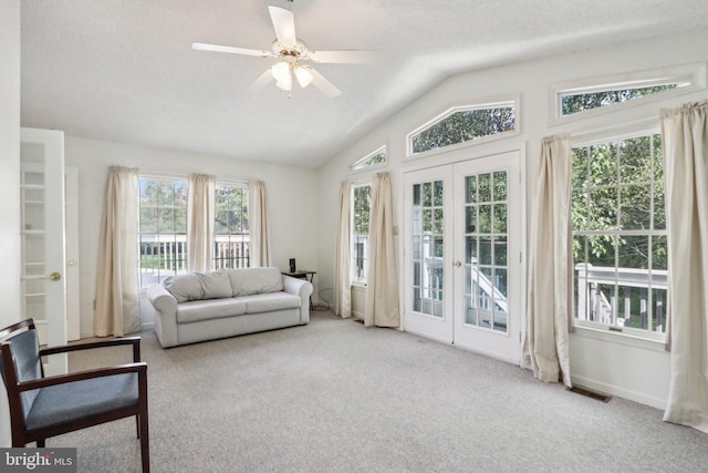 interior space with french doors, ceiling fan, vaulted ceiling, and a textured ceiling